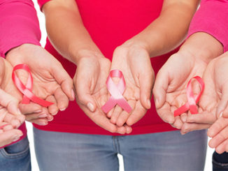 5 pairs of hands holding breast cancer ribbons
