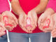 5 pairs of hands holding breast cancer ribbons