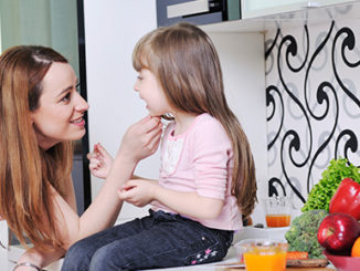 Mom and Daughter Sitting on Counter with Vegetables Epigenetics