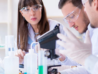 3 scientists at a bench working